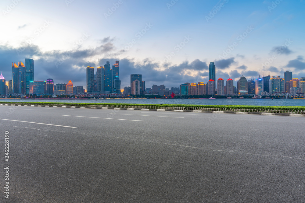 Empty asphalt road along modern commercial buildings in China,s cities Empty asphalt road along modern commercial buildings in China,s cities