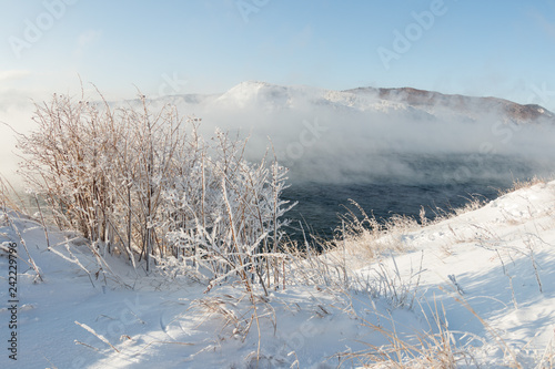 Baikal in winter is covered with water vapor by foggy steam in January