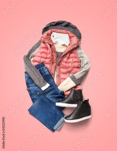 Collection of winter women clothing on pink background. Composition with jacket, jeans and shoes