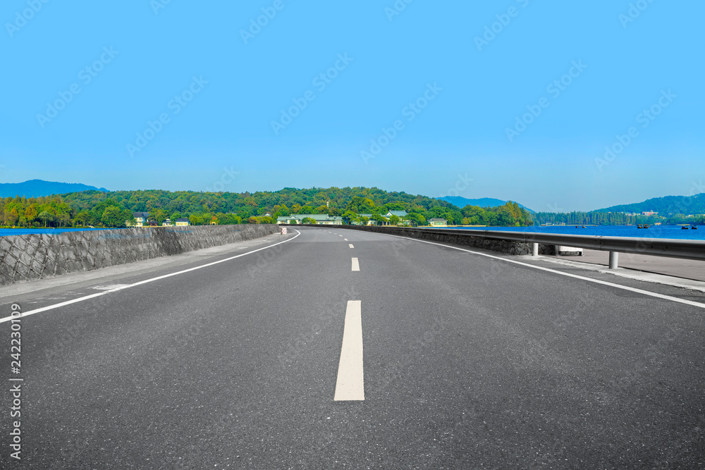 Fototapeta premium Empty asphalt road and natural landscape under the blue sky