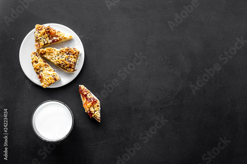 Children tradition evening dessert. Milk and homemade cookies on black background top view space for text
