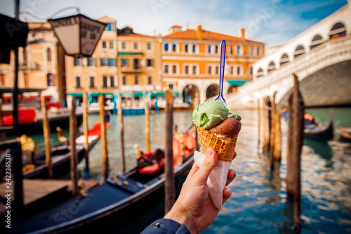 Hand man holds an Italian ice cream on background of Grand Canal and Handol in Venice, Italy. tourism.