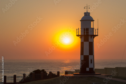 sunrise over the Indian ocean with lighthouse in the foreground 