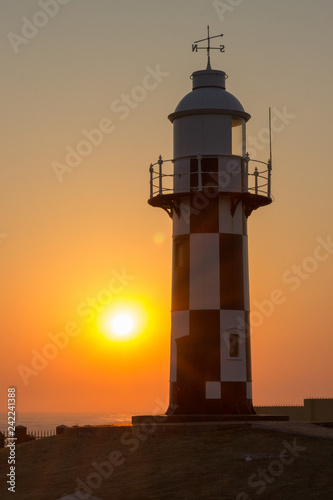lighthouse with sunrise over the ocean 