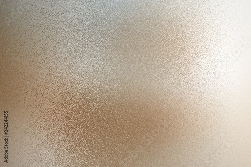 Texture of reflection on rough light brown metallic wall, abstract background