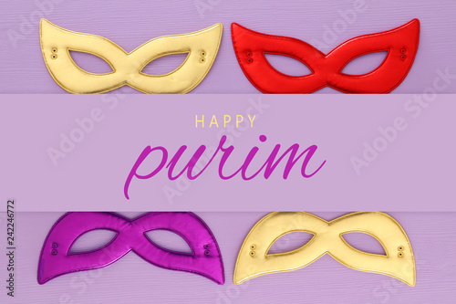 Purim celebration concept (jewish carnival holiday) over pink wooden background. Top view.