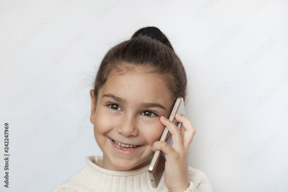 Portrait of a smiling cute girl holding smartphone over white background Portrait of a smiling cute girl holding smartphone over white background