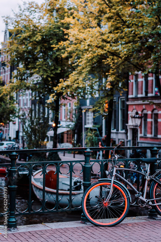 Bike parked on a bridge in Amsterdam, Netherlands. Typical cityscape © Igor Tichonow