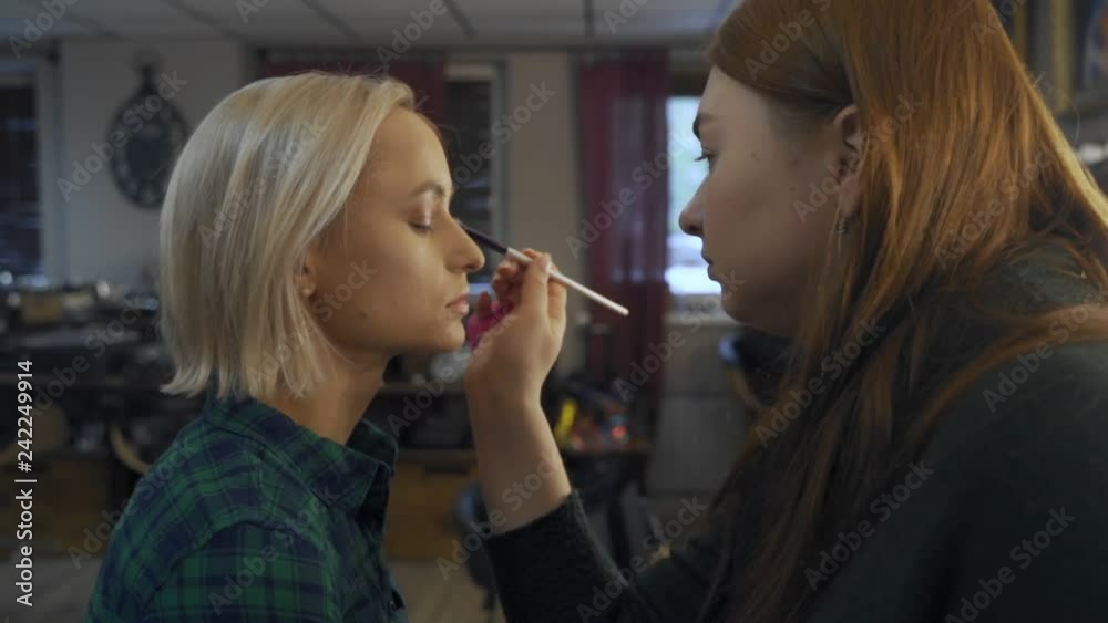 professional makeup artist making eye-makeup for young model professional makeup artist making eye-makeup for young model