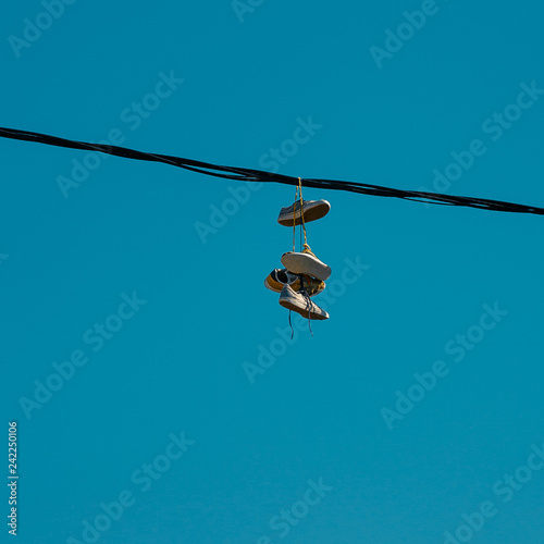 Sneakers hanging on a sky background. The concept of urban kultruta, sale of prohibited substances, ghetto photo