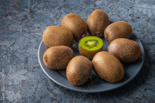 Kiwi fruit in a plate on a background of marble stone