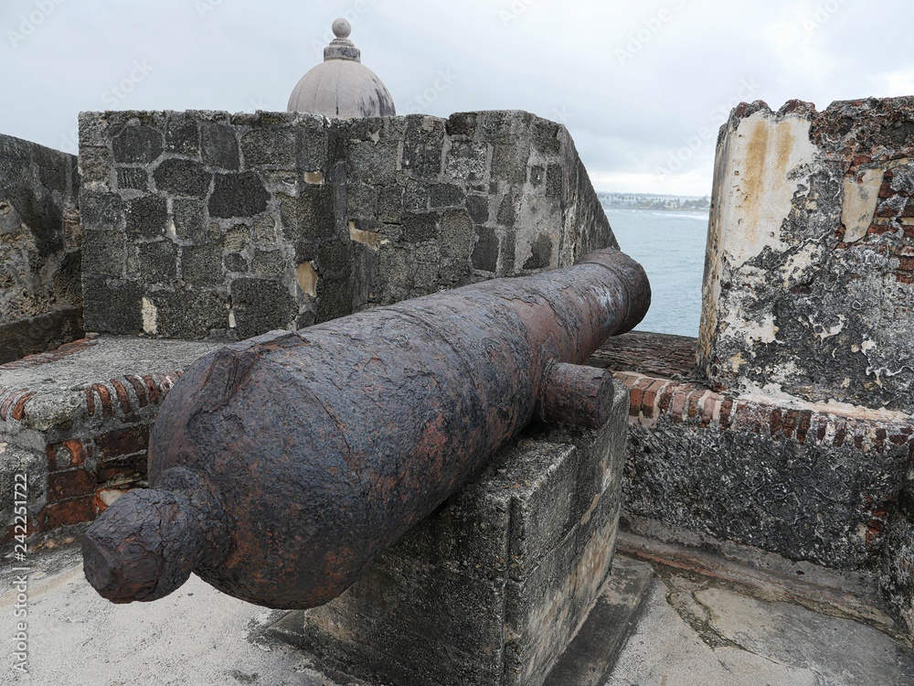 Cannon pointing out to sea with a view of one of the turrets, El Morro Fort, Old San Juan, Puerto Rico