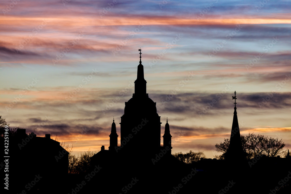 Silhouette of churches against dramatic winter sunset