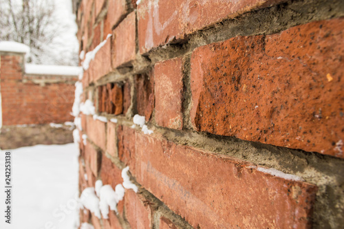 Texture of old red brick wall with snow closeup photo
