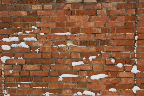 Texture of old red brick wall with snow