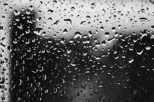 Raindrops on a window pane black and white closeup photo