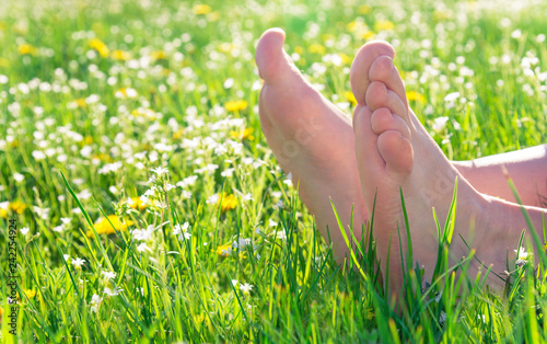 bare feet on spring grass and flowers