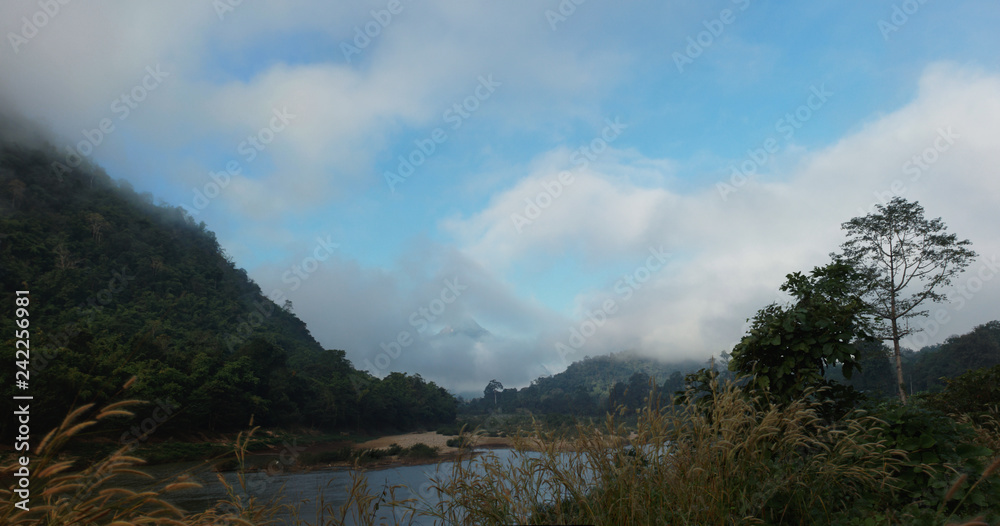 panoramic view of the Salween River twisting along a cloud covered mountain range near Myanmar, Southeast Asia