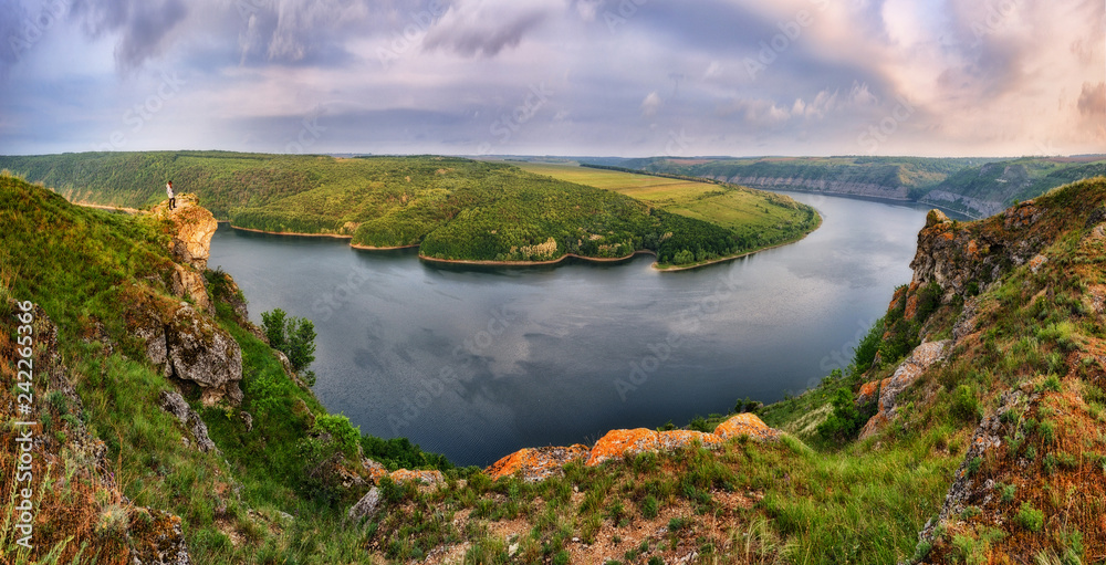 Obraz premium tourist over the canyon of the picturesque river. girl stands on a cliff above the canyon. autumn morning
