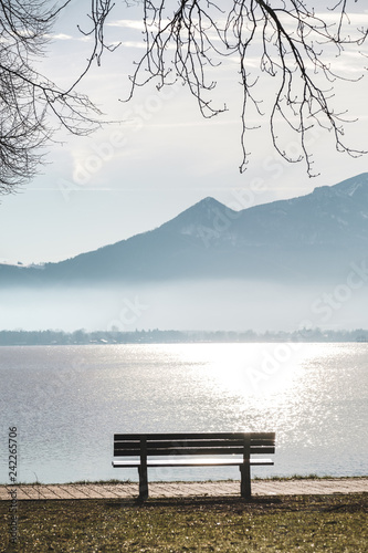 Sitzbank am Ufer des Chiemsee mit Bergen