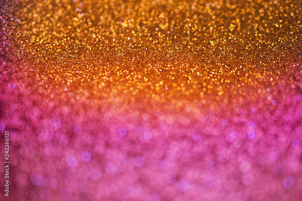 colorful glowing golden ,orange and purple shiny glitters texture background for holidays concept 