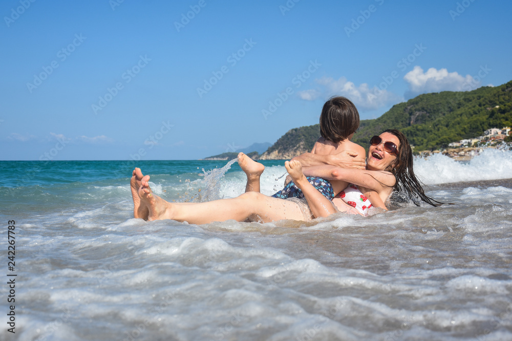 Mother and son playing on the beach. Family having fun on beach on travel vacation summer holidays