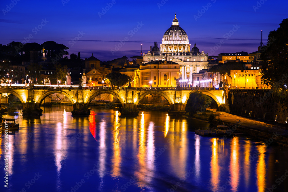 Night view of St. Peter's Basilica in Vatican city with the bridge over the Tiber river, Rome, Italy