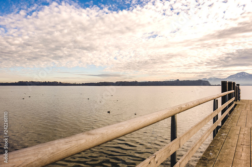 Steg am Chiemsee mit Sonnenuntergang und Bergen