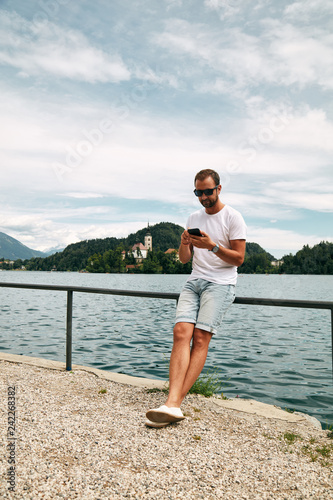 Modern guy using cellphone in the European city. © Kitja