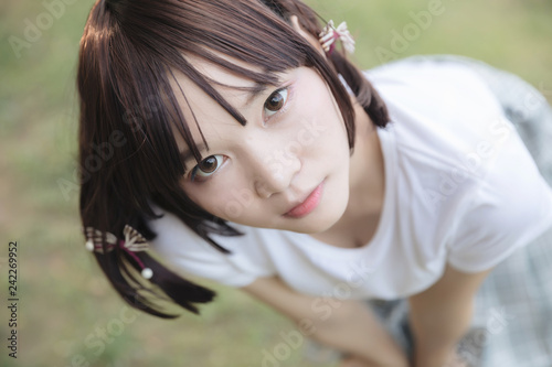 portrait of asian girl with white shirt and skirt looking in outdoor nature vintage film style