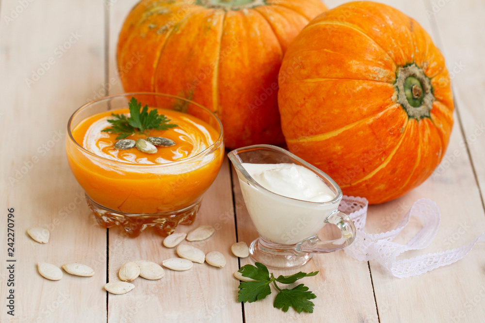 home made pumpkin cream soup with pumpkins and parsley leaves on white wooden table. cream soup of pumpkin home made pumpkin cream soup with pumpkins and parsley leaves on white wooden table. cream soup of pumpkin