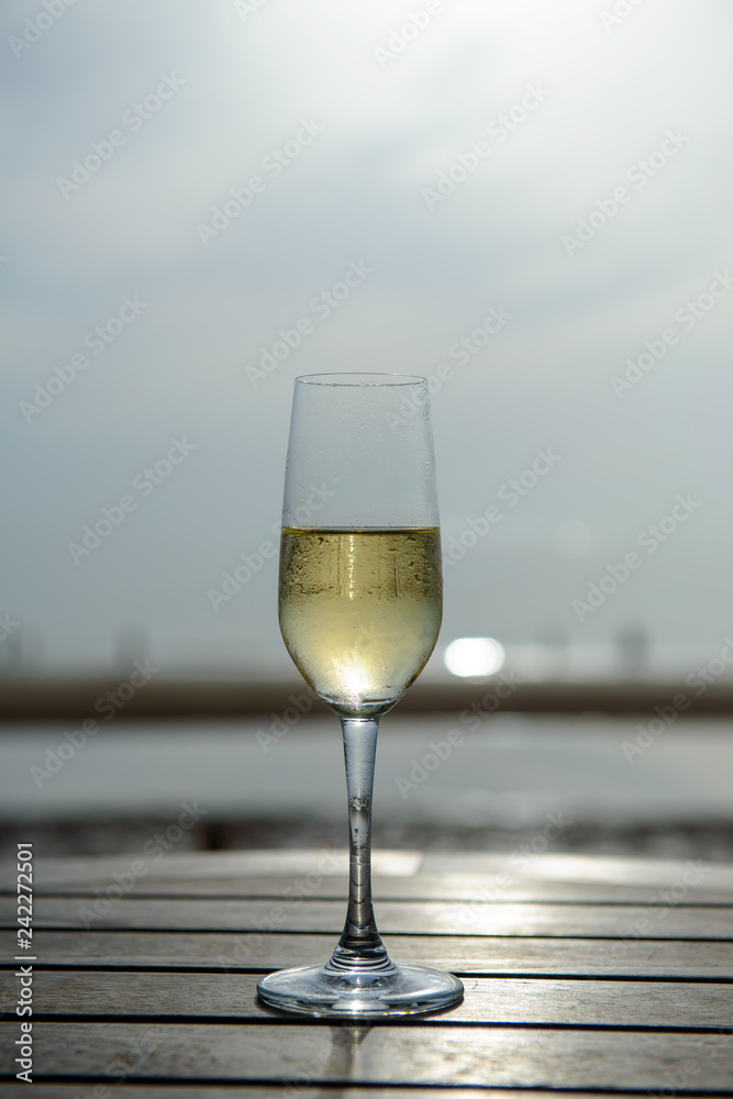 champagne glass with blurred sea and sky background