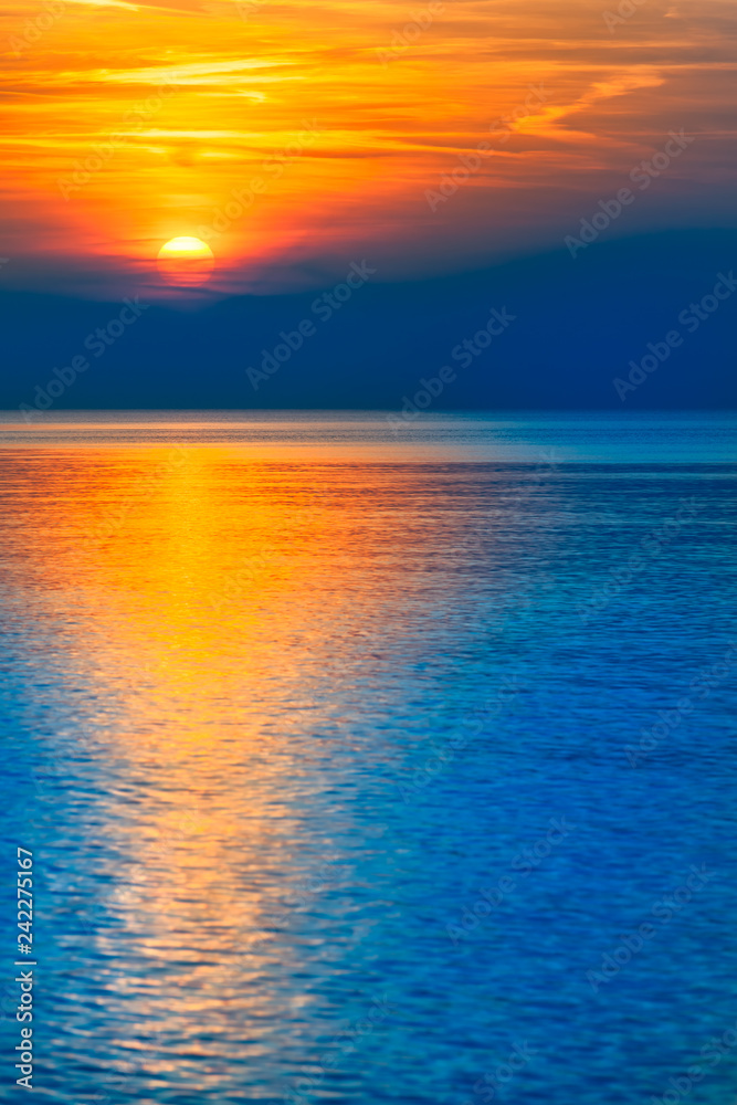 Gorgeous End of Day at the Sea / Natural spectacle - colorful blue and orange reflecting sunset at sea horizon (copy space)