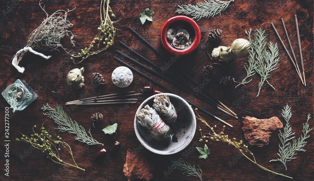 Various air element objects to use in witchcraft and wicca on a witch's  altar filled with evergreens dried herbs sage incense sticks for smoke  cleansing Stock Photo