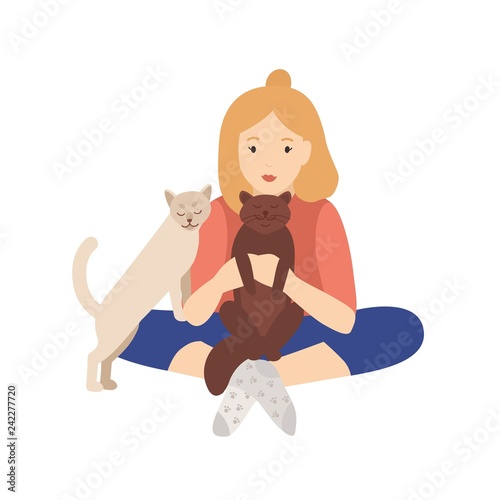 Girl holding, cuddling and stroking her cats. Young woman sitting cross-legge...