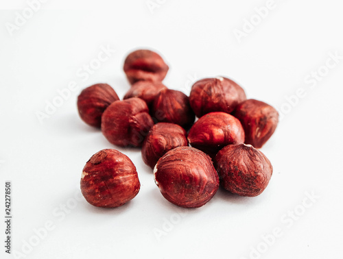 A pile of brown raw hazelnuts, isolated on white background.
