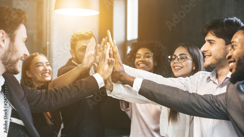 High-five for success. Diverse group of business colleagues in office