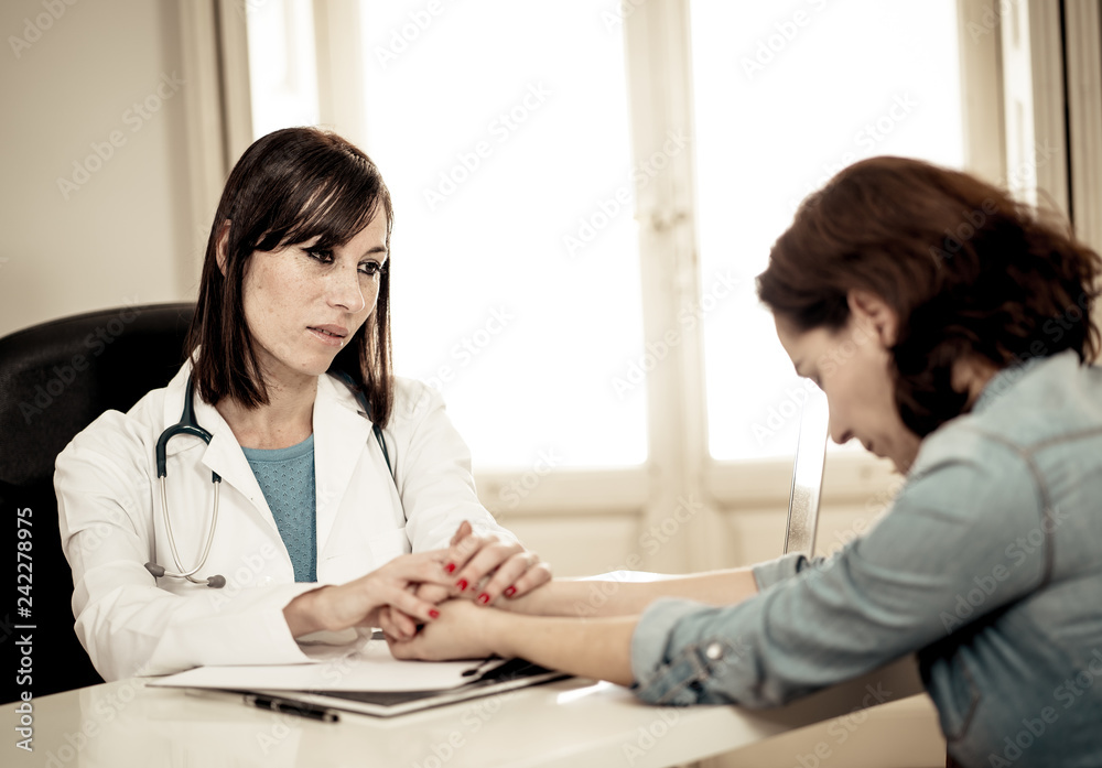 Female doctor explaining bad news diagnosis to desperate sad patient comforting her with sympathy Female doctor explaining bad news diagnosis to desperate sad patient comforting her with sympathy