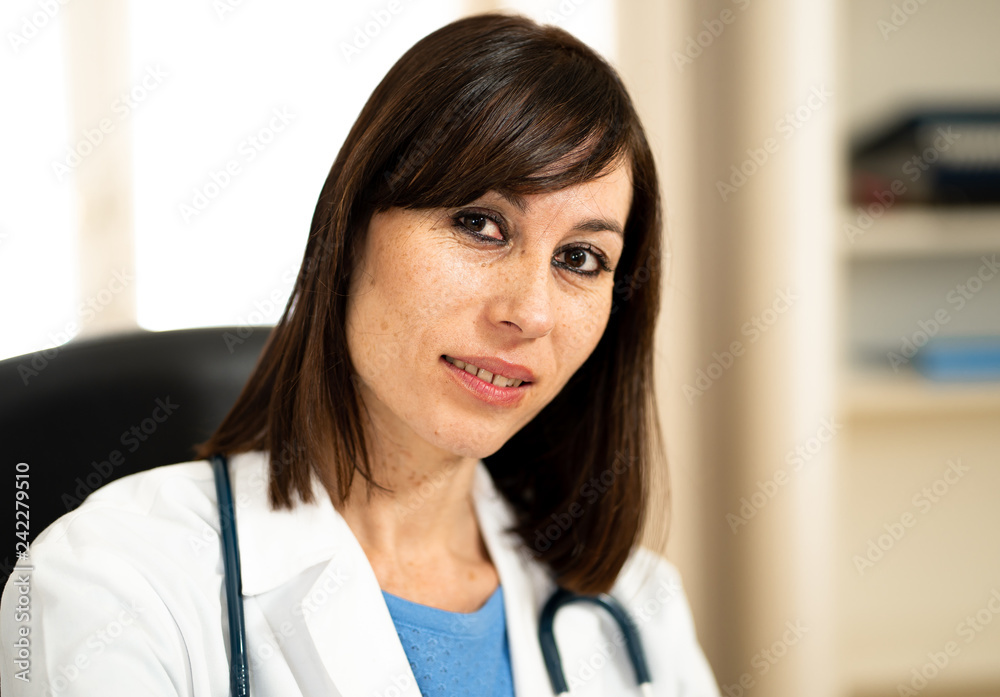 Female doctor working with stethoscope and clipboard in medical office with natural face expression Female doctor working with stethoscope and clipboard in medical office with natural face expression