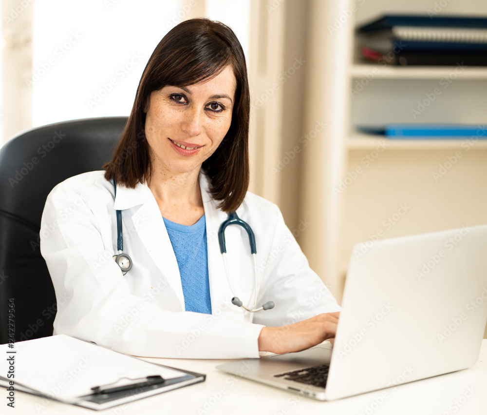 Female doctor working on medical expertise and searching information on laptop at hospital office Female doctor working on medical expertise and searching information on laptop at hospital office