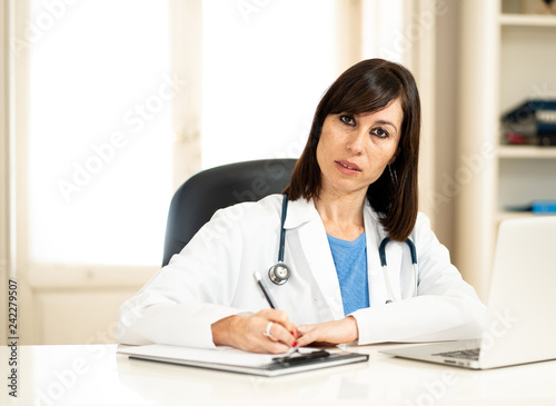 Successful female doctor working in clinic hospital office smiling and posing for the camera