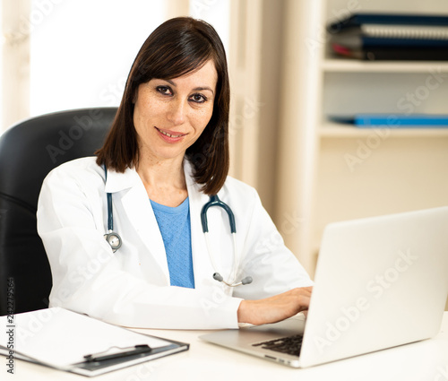 Female doctor working on medical expertise and searching information on laptop at hospital office