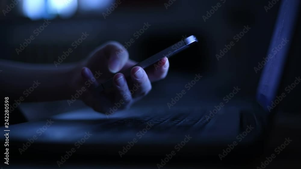 Using mobile phone at night indoors, low key footage with selective focus