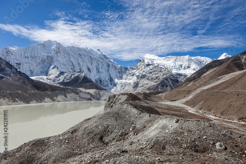 Grey moraine lake and snowy mountain peak in Himalayas, Nepal. Delightful photo. photo