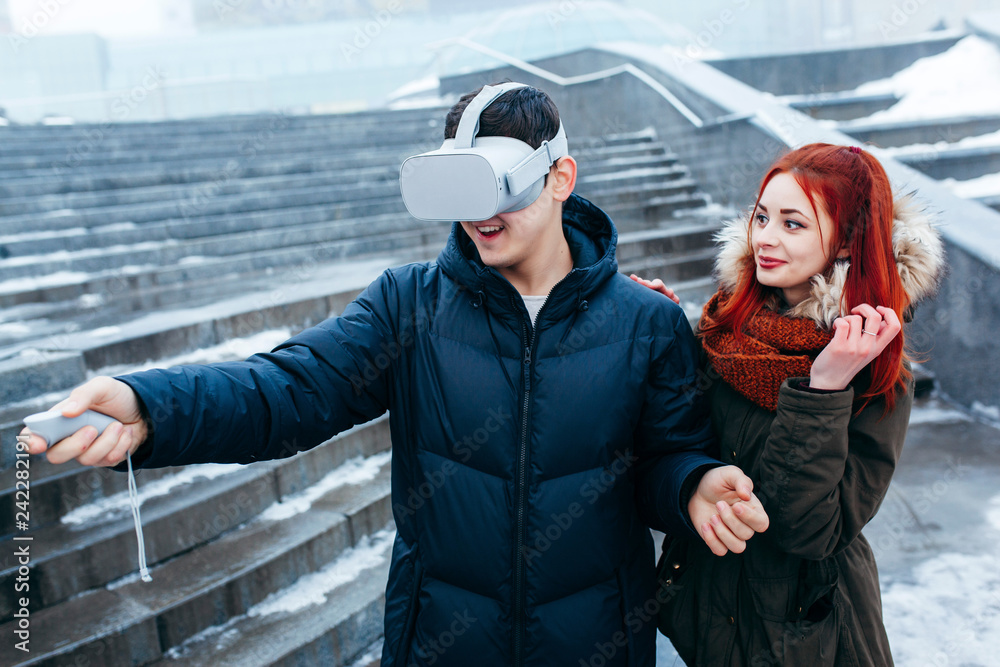 Obraz premium Young couple experiencing virtual reality (VR) on the street