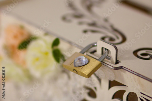 Close-up of lock for gift box decorated with flowers and ribbons.