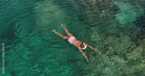 Summer image of beautiful girl swimming and lying on the back in the turquese sea water. Slim tanned body. Amazing sea landscape. Happy vacation and relaxing. Cyprus Green bay. photo