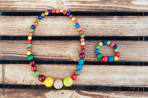 Handmade Colored Jewelry. Colored beads and wood bracelet. Wooden background