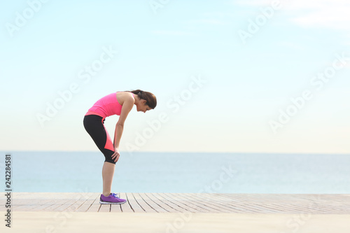 Exhausted runner resting on the beach after exercise