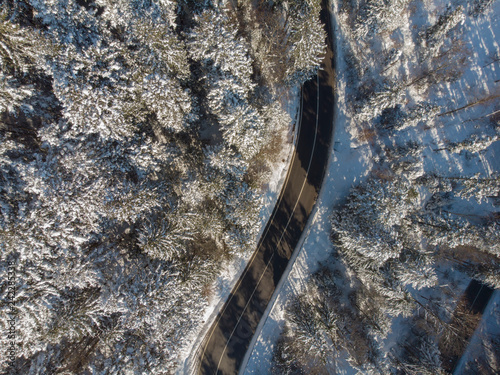 straight road in winter mountain landscape. Aerial view of forest